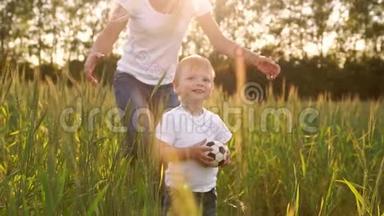 幸福家庭的概念.. 在黑麦田里，孩子在夕阳下的阳光下穿过田野，凝视着